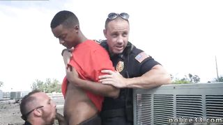 One cop holds the suspect back as the other cops enjoys the tasty treat of a big long black dick